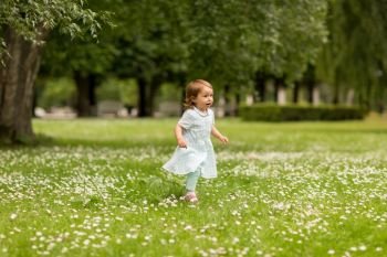 childhood, leisure and people concept - happy little baby girl running at park in summer. happy little baby girl running at park in summer