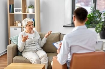 geriatric psychology, mental therapy and old age concept - senior woman patient and psychologist at psychotherapy session. senior woman patient and psychologist