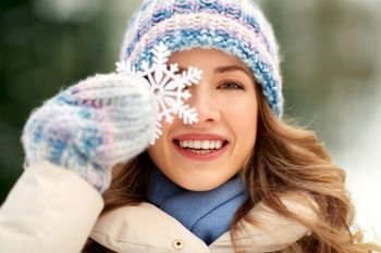people, season and leisure concept - portrait of happy smiling woman with snowflake in winter forest. portrait of woman with snowflake in winter
