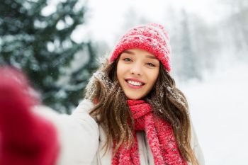 christmas, season and people concept - happy smiling woman taking selfie outdoors in winter park. smiling woman taking selfie outdoors in winter
