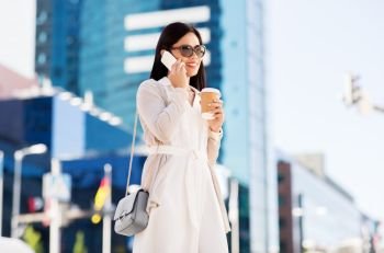 communication, lifestyle and technology concept - happy smiling young asian woman in sunglasses with takeaway coffee cup calling on smartphone on city street. smiling asian woman calling on smartphone in city