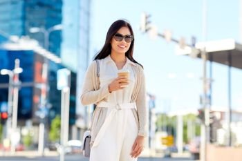 lifestyle and people concept - happy smiling young asian woman in sunglasses with takeaway coffee cup on city street. smiling woman with takeaway coffee cup in city