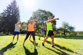 fitness, sport, martial arts, self-defense and healthy lifestyle concept - group of people or sportsmen exercising at boot camp in summer park. group of friends or sportsmen exercising at park