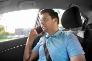 transport, technology and communication concept - male passenger calling on smartphone on back seat of taxi car. male passenger calling on smartphone in taxi car