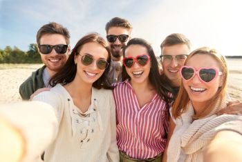 friendship, leisure and people concept - group of happy friends taking selfie on beach in summer. happy friends taking selfie on summer beach