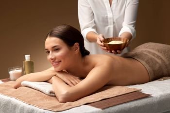 wellness, beauty and cosmetology concept - beautiful young woman and cosmetologist holding mask in bowl at spa. woman and cosmetologist with mask in bowl at spa