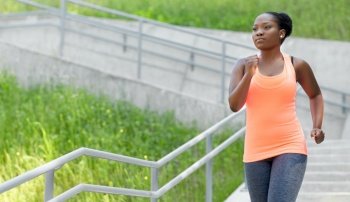 fitness, sport and healthy lifestyle concept - young african american woman running downstairs. young african american woman running downstairs