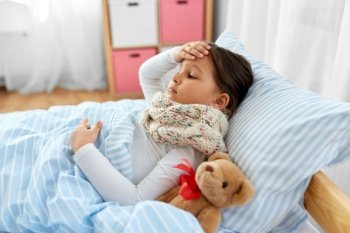 health, children and people concept - sick girl lying in bed at home. sick girl lying in bed at home