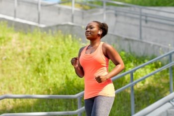 fitness, sport and healthy lifestyle concept - young african american woman running outdoors. african american woman running outdoors