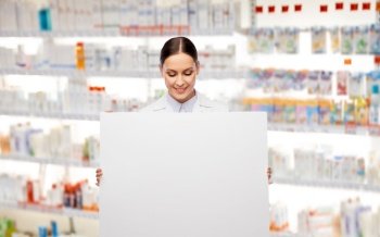 medicine, profession and healthcare concept - happy smiling female pharmacist or doctor holding white board over pharmacy background. happy smiling female pharmacist with white board