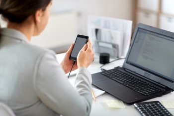 business, corporate, technology and people concept - businesswoman with smartphone working at office. businesswoman with smartphone working at office