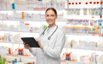 medicine, profession and healthcare concept - happy smiling female doctor in white coat with tablet pc computer and stethoscope over pharmacy background. happy female doctor with tablet pc and stethoscope