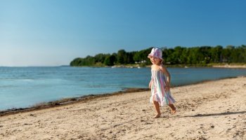 childhood, leisure and people concept - happy little baby girl running along summer beach. happy baby girl running on summer beach