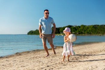 family, leisure and people concept - happy father and baby daughter playing ball on summer beach. happy father and daughter playing ball on beach
