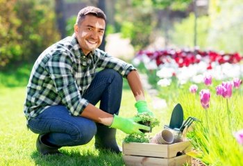 skin health, gardening and people concept - happy smiling middle-aged man man with vitiligo on his face and tools in box taking working at summer garden. middle-aged man with vitiligo working at garden