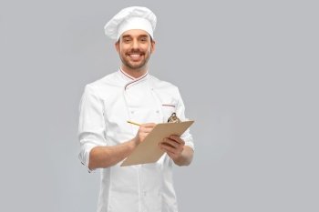 cooking, culinary and people concept - happy smiling male chef with clipboard and pencil over grey background. happy smiling male chef with clipboard and pencil