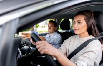 driver courses, exam and people concept - young woman and driving school instructor with clipboard in car. car driving school instructor and young driver