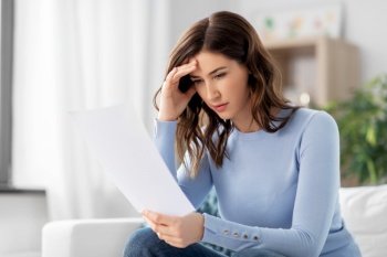 people and problems concept - stressed woman with paper sheet at home. stressed woman with paper sheet at home