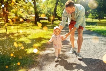 family, fatherhood and people concept - happy smiling father with baby daughter walking at summer park. happy father with baby daughter walking at park
