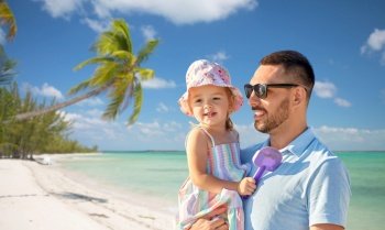 family, fatherhood and travel concept - happy smiling father with little daughter over tropical beach background in french polynesia. happy father with little daughter on beach