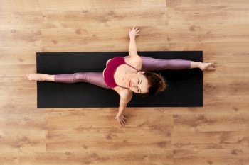 fitness, sport and healthy lifestyle concept - woman doing yoga exercise on mat at studio. woman doing yoga exercise on mat at studio