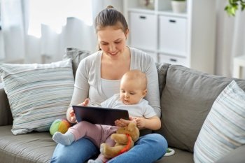 family, motherhood, technology and people concept - happy smiling mother and little baby daughter with tablet pc computer at home. happy mother and baby girl with tablet pc at home