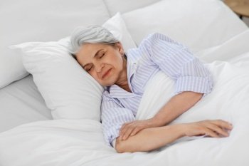 old age and people concept - senior woman sleeping in bed at home bedroom. senior woman sleeping in bed at home bedroom