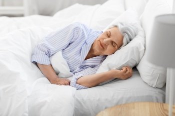 old age and people concept - senior woman sleeping in bed at home bedroom. senior woman sleeping in bed at home bedroom