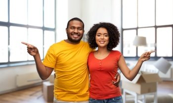 moving, real estate and people concept - happy african american couple over new home background. happy african american couple at new home