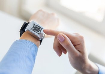 technology and health care concept - close up of woman’s hands with qr code on smart watch at office. woman’s hands with qr code on smart watch