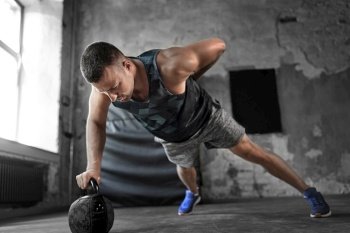 sport, bodybuilding, fitness and people concept - young man doing kettlebell push-ups in gym. young man doing kettlebell push-ups in gym