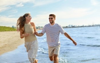 summer holidays and people concept - happy couple running along beach. happy couple running along summer beach