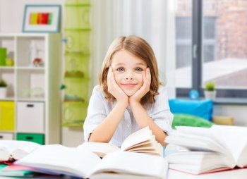 education and school concept - happy smiling student girl reading book over home background. smiling student girl reading book at home