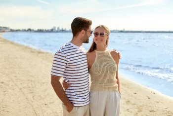 leisure, relationships and people concept - happy couple in sunglasses on summer beach. happy couple on summer beach