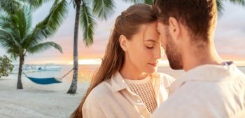 leisure, relationships and people concept - happy couple with closed eyes over tropical beach background in french polynesia. happy couple with closed eyes on tropical beach