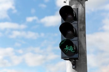 road and signals concept - close up of green traffic light for bicycle over blue sky. green traffic light for bicycle over blue sky
