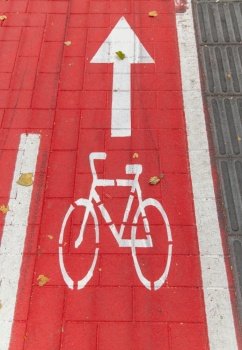 traffic, marking and city concept - close up of red bike lane or road with signs of bicycles and two way arrows on street. bike lane or red road with signs of bicycles