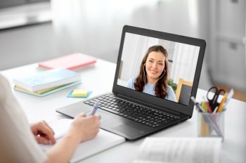 education, school and distant learning concept - female student woman with laptop computer having video call or online class with teacher at home. student with laptop having video call with teacher