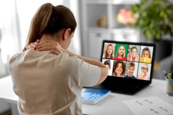 distant education, remote job and health concept - tired female teacher having online class with group of students on laptop computer and touching her aching neck at home office. tired teacher with laptop touching neck at home