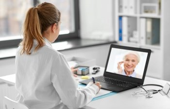 healthcare, technology and medicine concept - female doctor with laptop computer having video call with patient at hospital. doctor with laptop having video call with patient