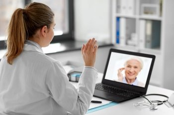 healthcare, technology and medicine concept - female doctor with laptop computer having video call with patient at hospital. doctor with laptop having video call with patient