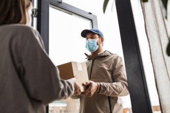 health protection, safety and pandemic concept - delivery man in face protective mask giving parcel box to female customer at home. delivery man in mask giving parcel to customer