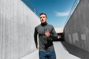 fitness, sport and healthy lifestyle concept - young man running outdoors. young man running outdoors