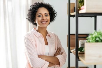 home improvement, decoration and people concept - happy smiling woman standing at shelf at home. happy smiling woman standing at shelf at home