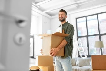 moving, people and real estate concept - happy smiling man holding box with stuff at new home. happy man with box moving to new home