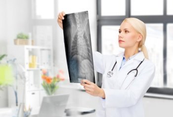 medicine, pet and healthcare concept - female veterinarian doctor looking at animal’s x-ray over vet clinic office background. veterinarian with animal’s x-ray at vet clinic
