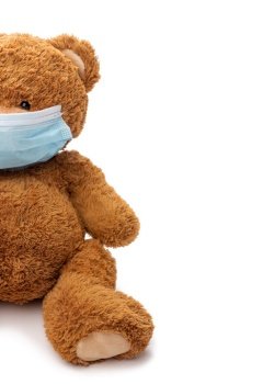 medicine, healthcare and pandemic concept - teddy bear toy in protective medical mask on white background. teddy bear toy in protective medical mask