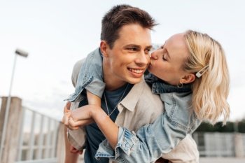 summer holidays, love and people concept - happy young couple kissing and hugging on roof top. happy young couple kissing and hugging on roof top
