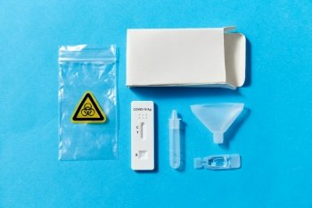 medicine, self testing and pandemic concept - coronavirus saliva test kit on blue background. coronavirus salvia self testing kit on blue