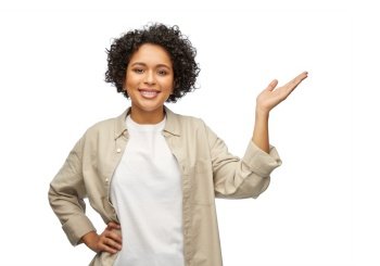 people, ethnicity and portrait concept - happy smiling woman in shirt holding something imaginary on her hand over white background. happy smiling woman holding something on her hand
